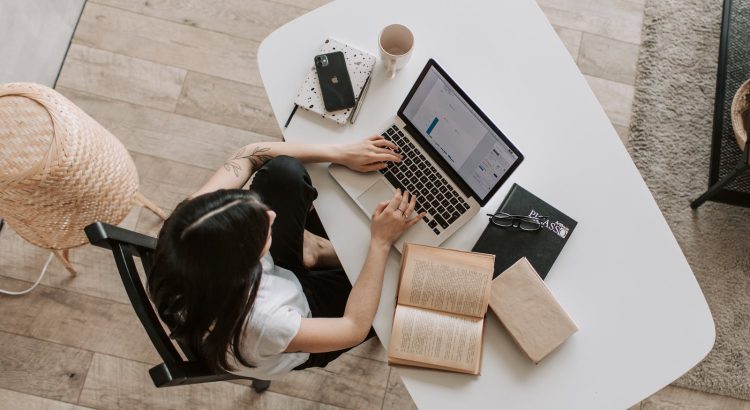 Young lady typing on keyboard of laptop in living room